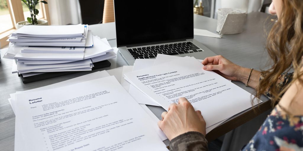 Job seeker preparing resumes and cover letters at desk