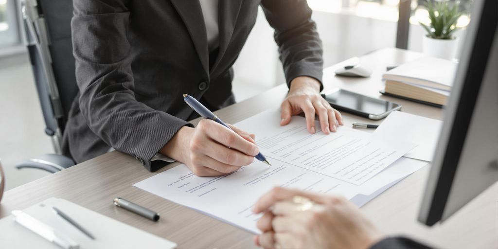 Person in business attire preparing documents at modern desk.
