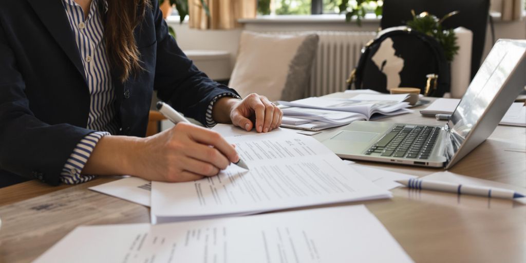 Person reviewing documents at desk in modern office