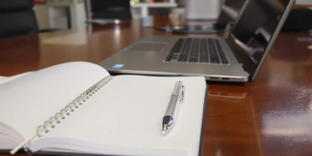 Laptop, notebook, and pen.