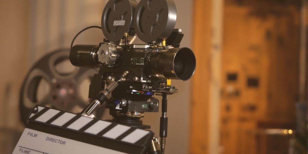 Filmmaker's tools, director's chair, camera, film reel.