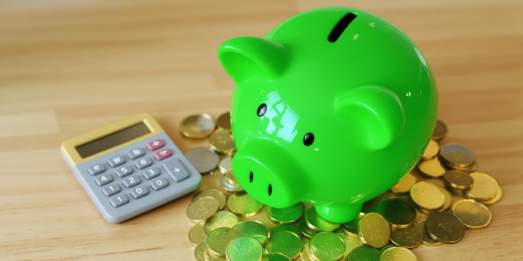 Piggy bank, coins, and a calculator on a table.