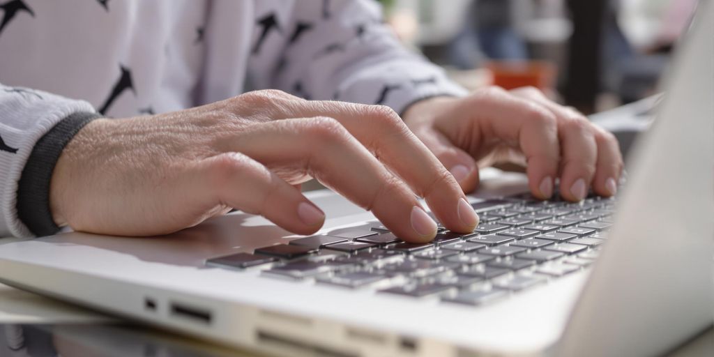 Person typing cover letter on laptop.