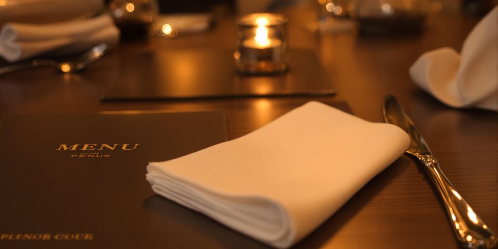 Polished silverware, a neatly folded napkin, and a menu.