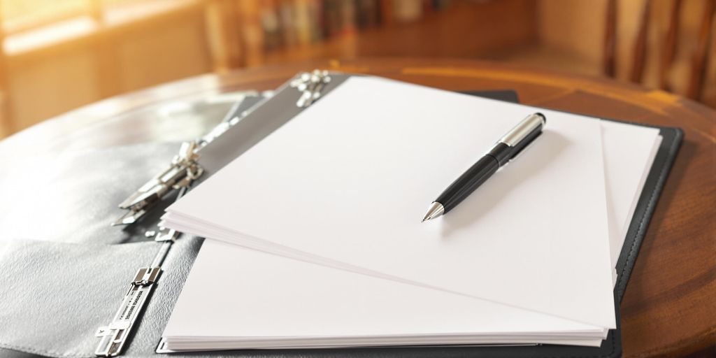Open folder, pen, and a few paper sheets